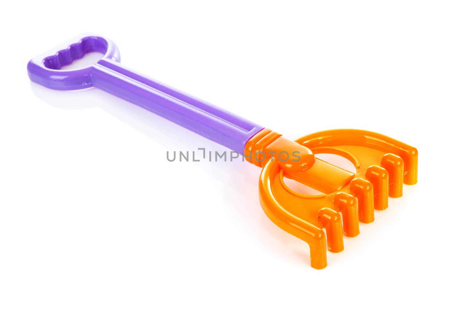Colorful plastic rake over white background