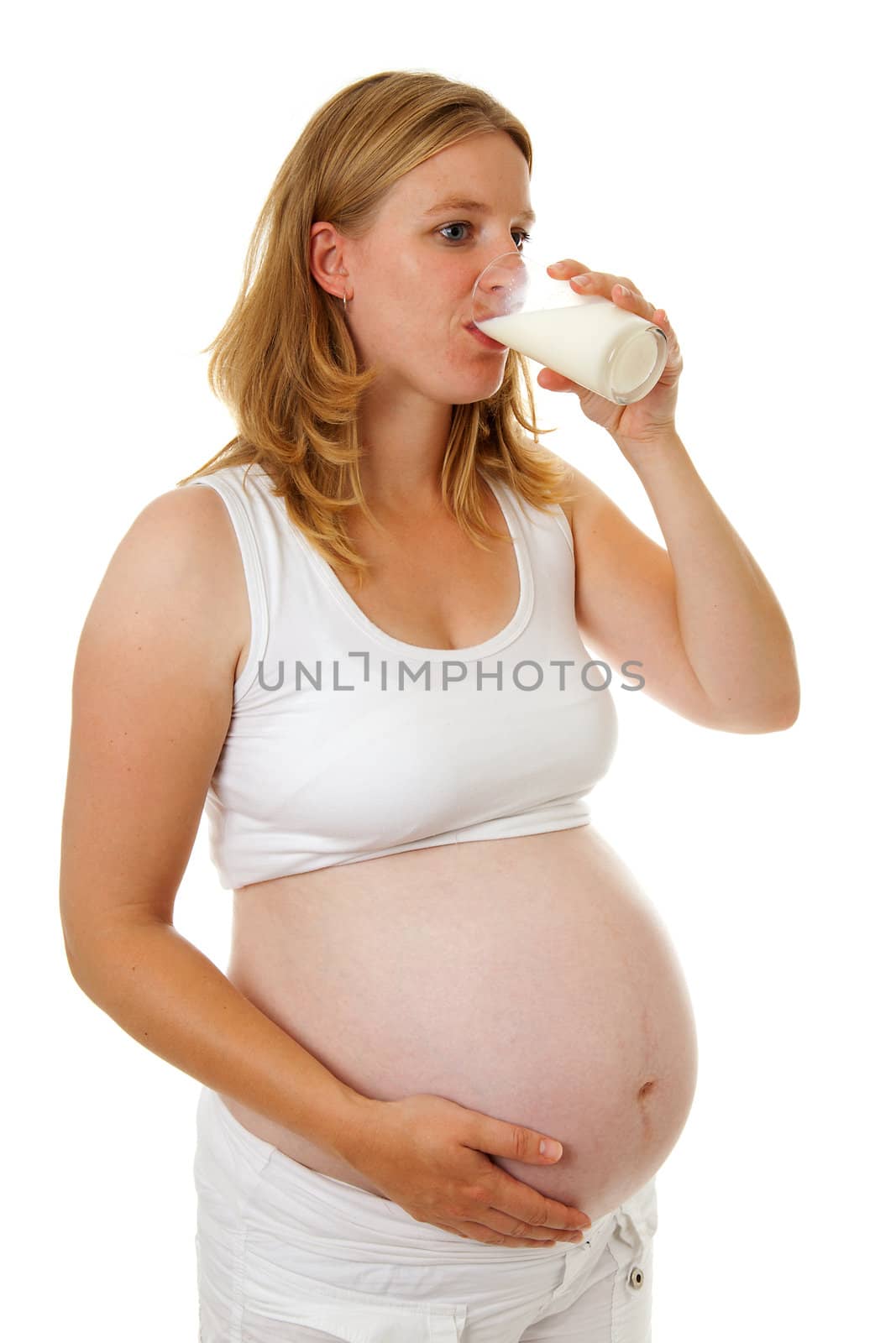 Pregant woman is drinking milk over white background