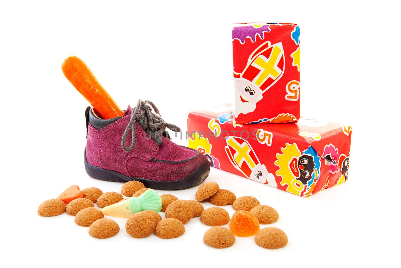 purple little children's shoe with presents and pepernoten ( ginger nuts), traditional for Sinterklaas in the Netherlands over white background