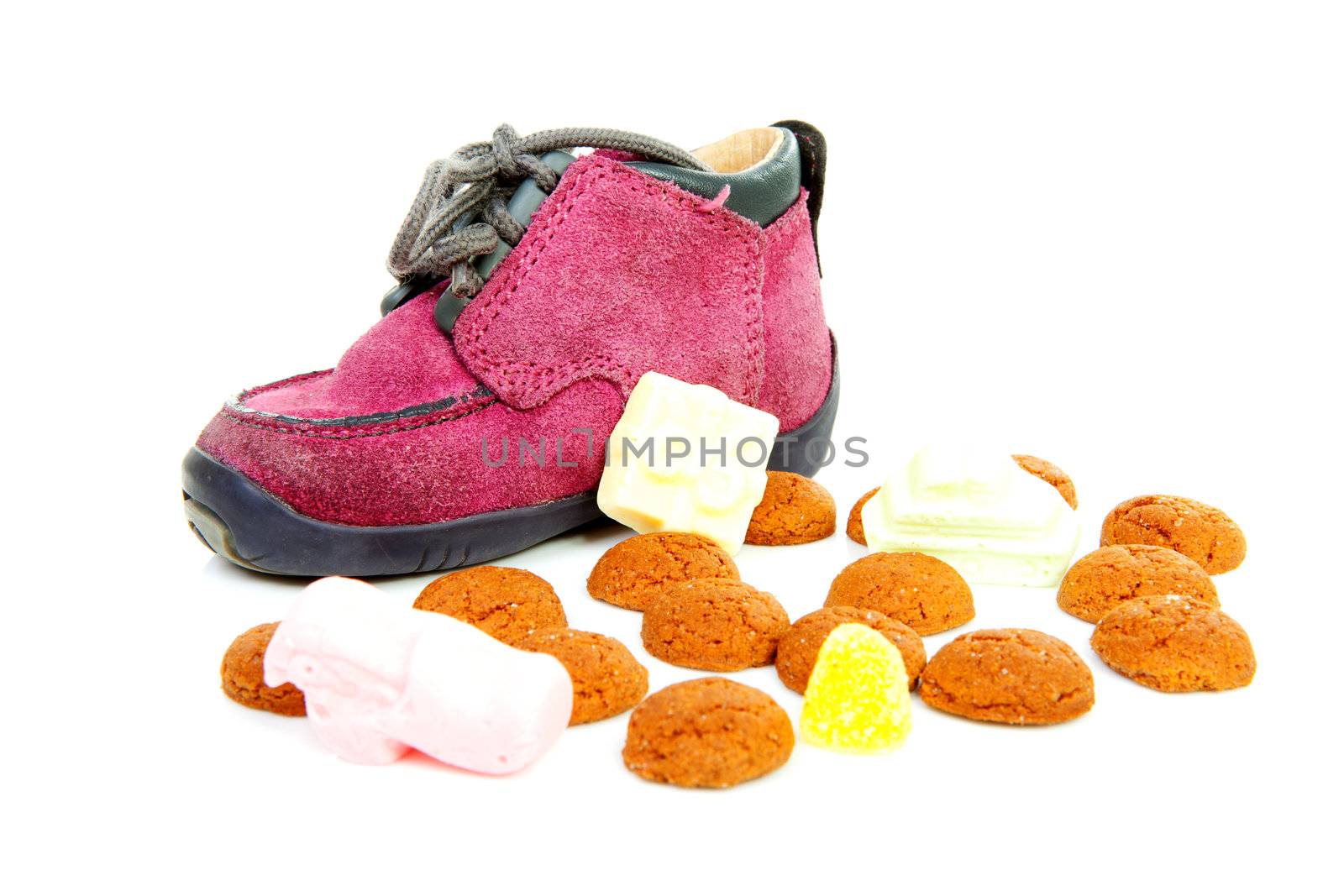 purple little children's shoe with pepernoten ( ginger nuts), traditional for Sinterklaas in the Netherlands over white background