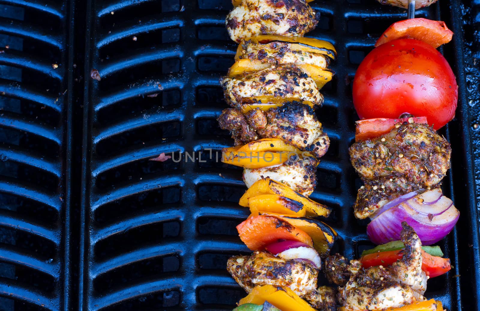 chicken and pepper kebabs slowly cooking on the barbecue by smikeymikey1