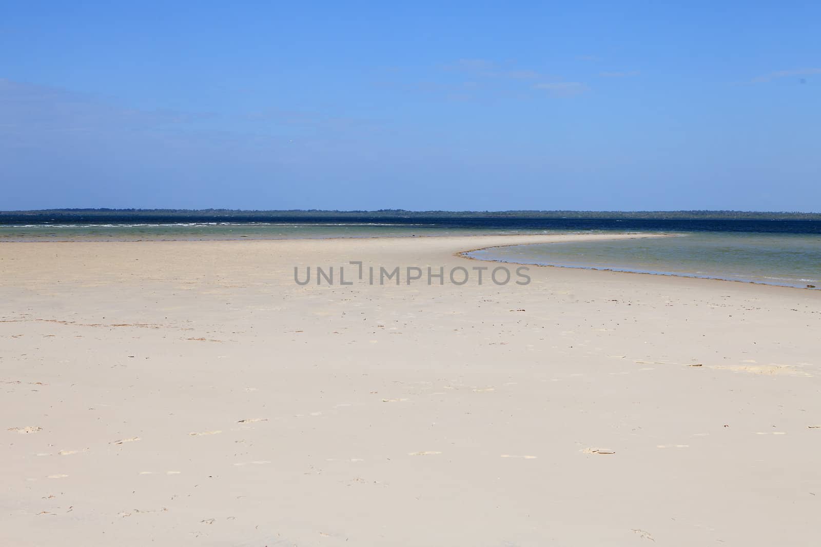 Empty tropical beach with foot steps in the sand
