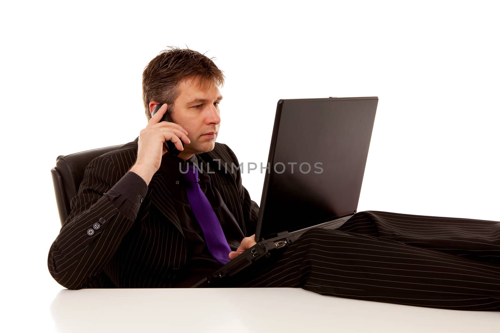 Businessman sitting relaxed with feet on desk is calling over white background