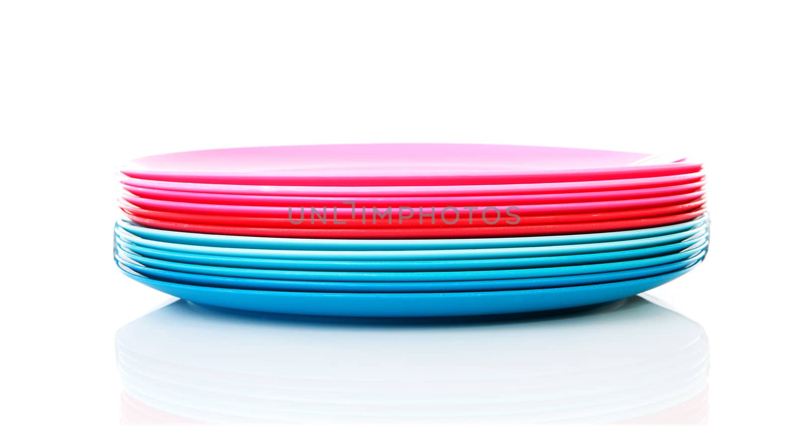 Pile of colorful plastic plates over white background