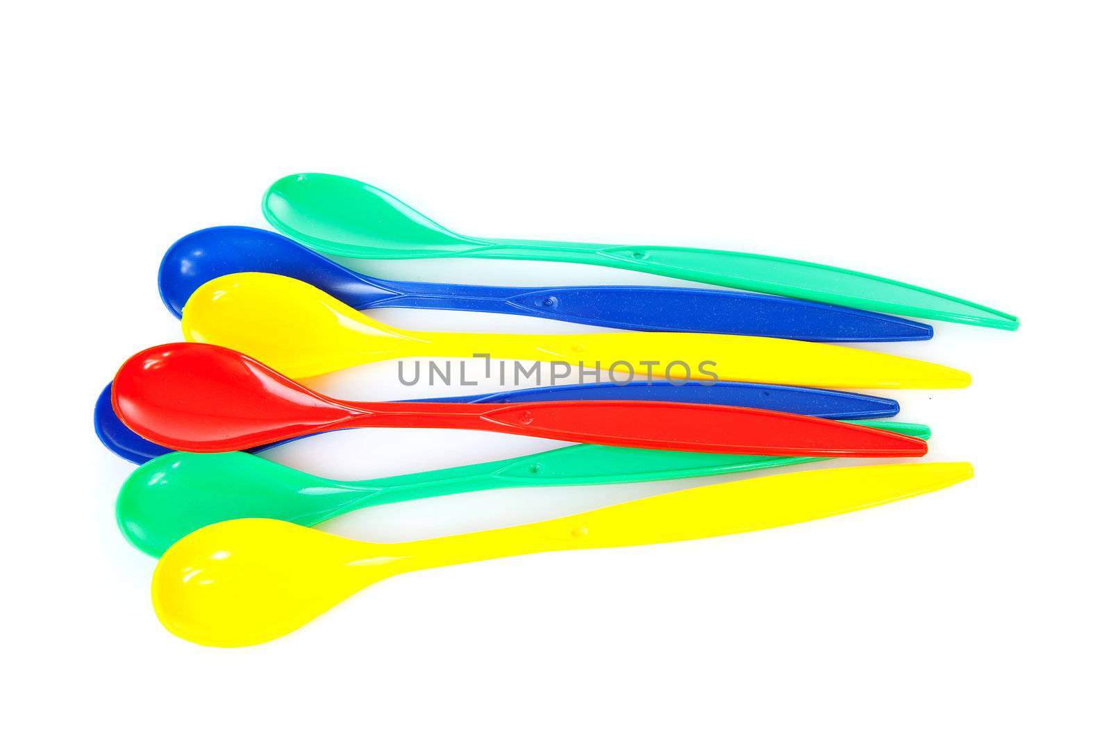 pile of colorful plastic spoons over white background