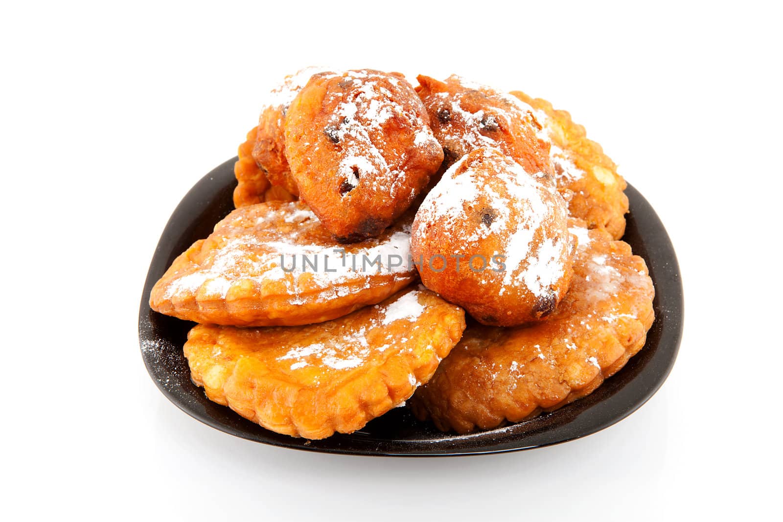 Plate with Dutch donut also known as oliebollen and apple turnovers, traditional New Year's eve food isolated on white background 
