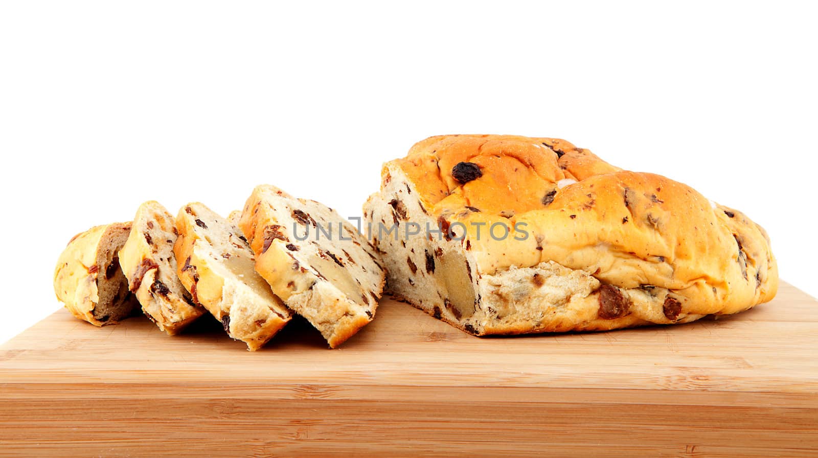 slices of raising bread on wooden cutting board over white background 
