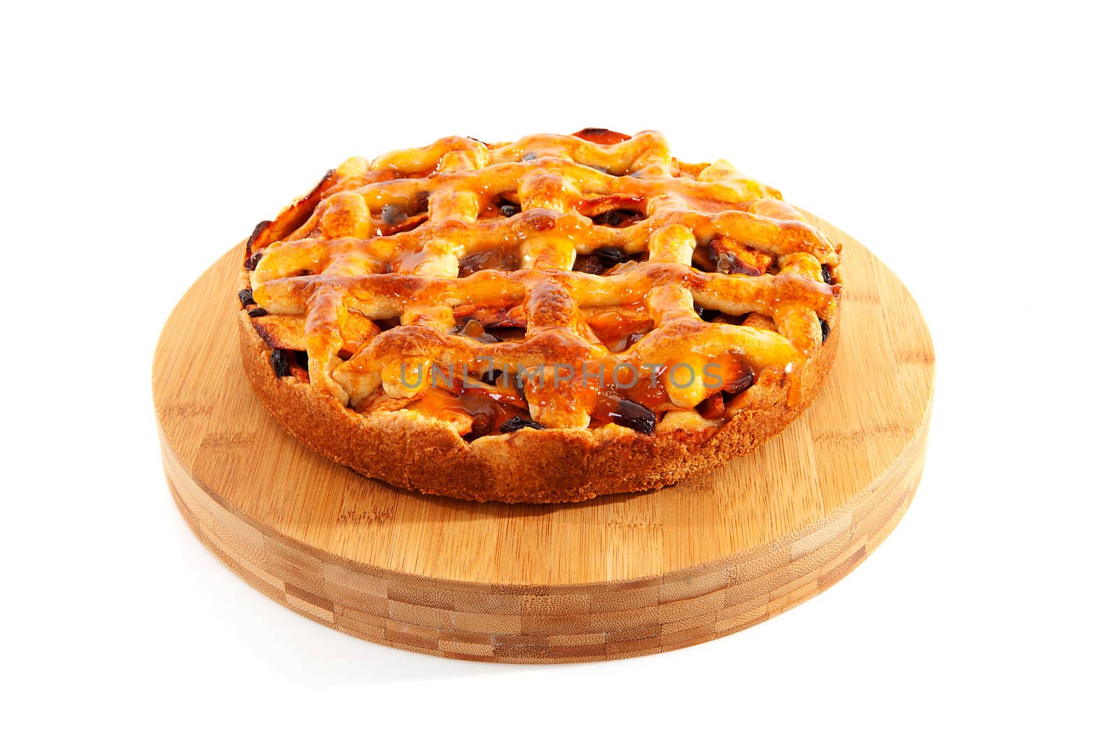Delicious home baked apple pie on wooden cutting board isolated on white background