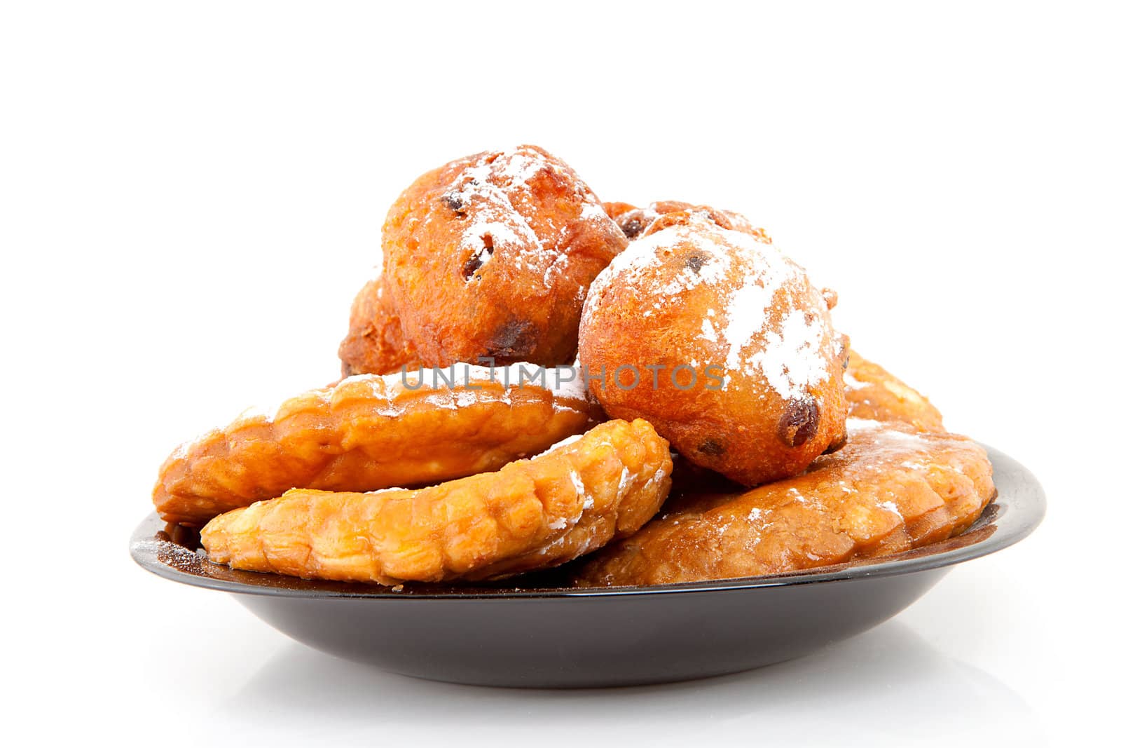 Plate with Dutch donut also known as oliebollen and apple turnovers, traditional New Year's eve food isolated on white background