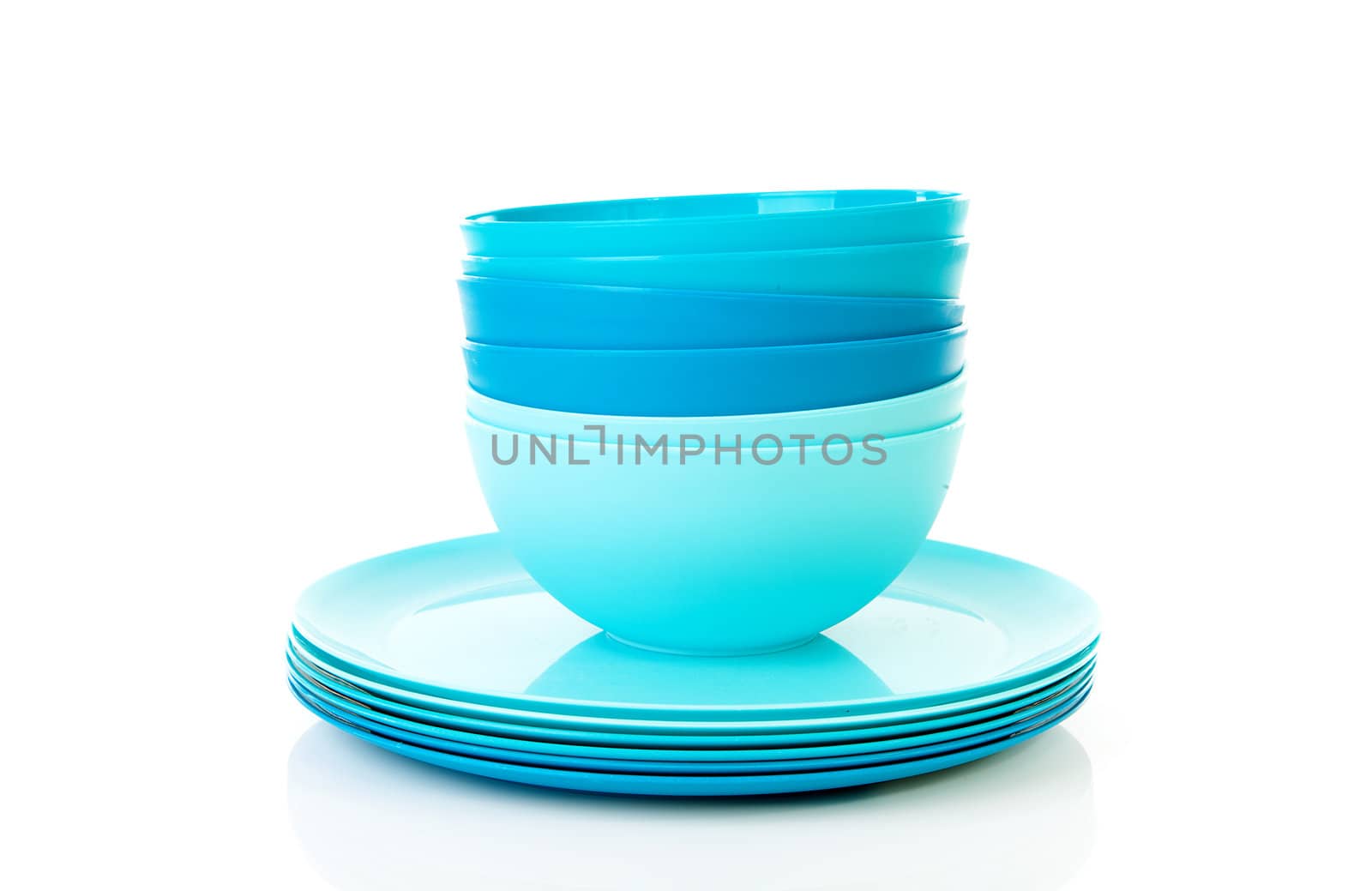 Pile of blue plastic plates and bowls over white background