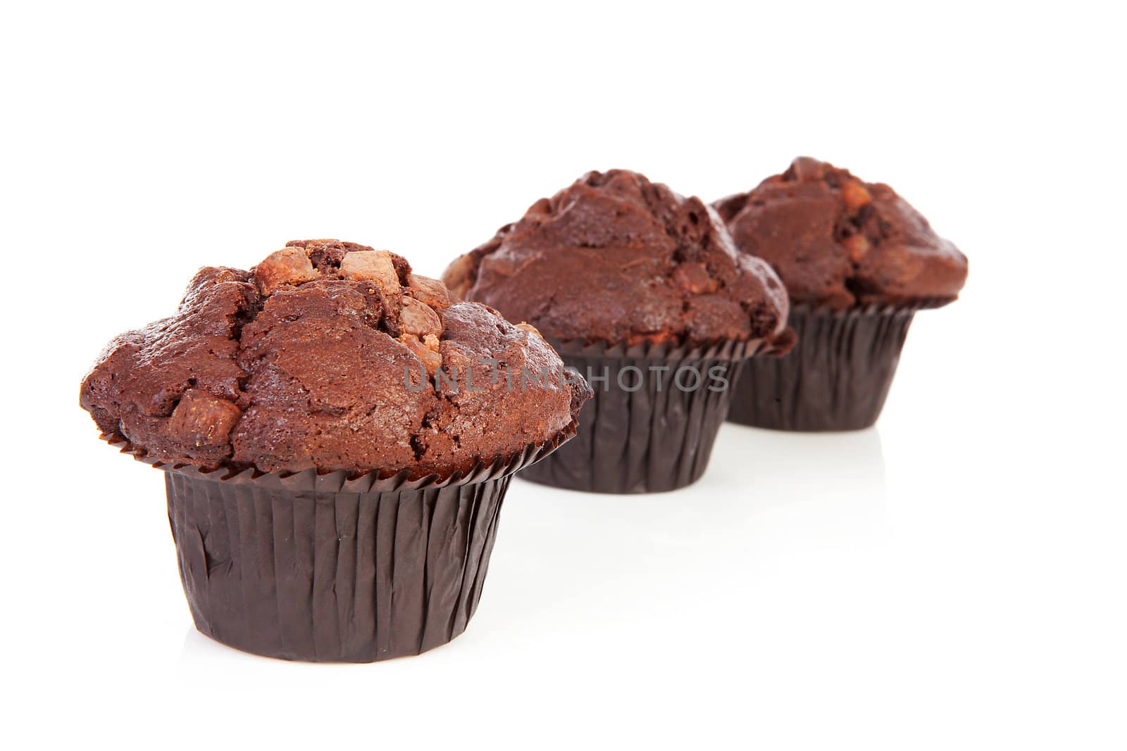 Three chocolate cupcakes isolated on white background