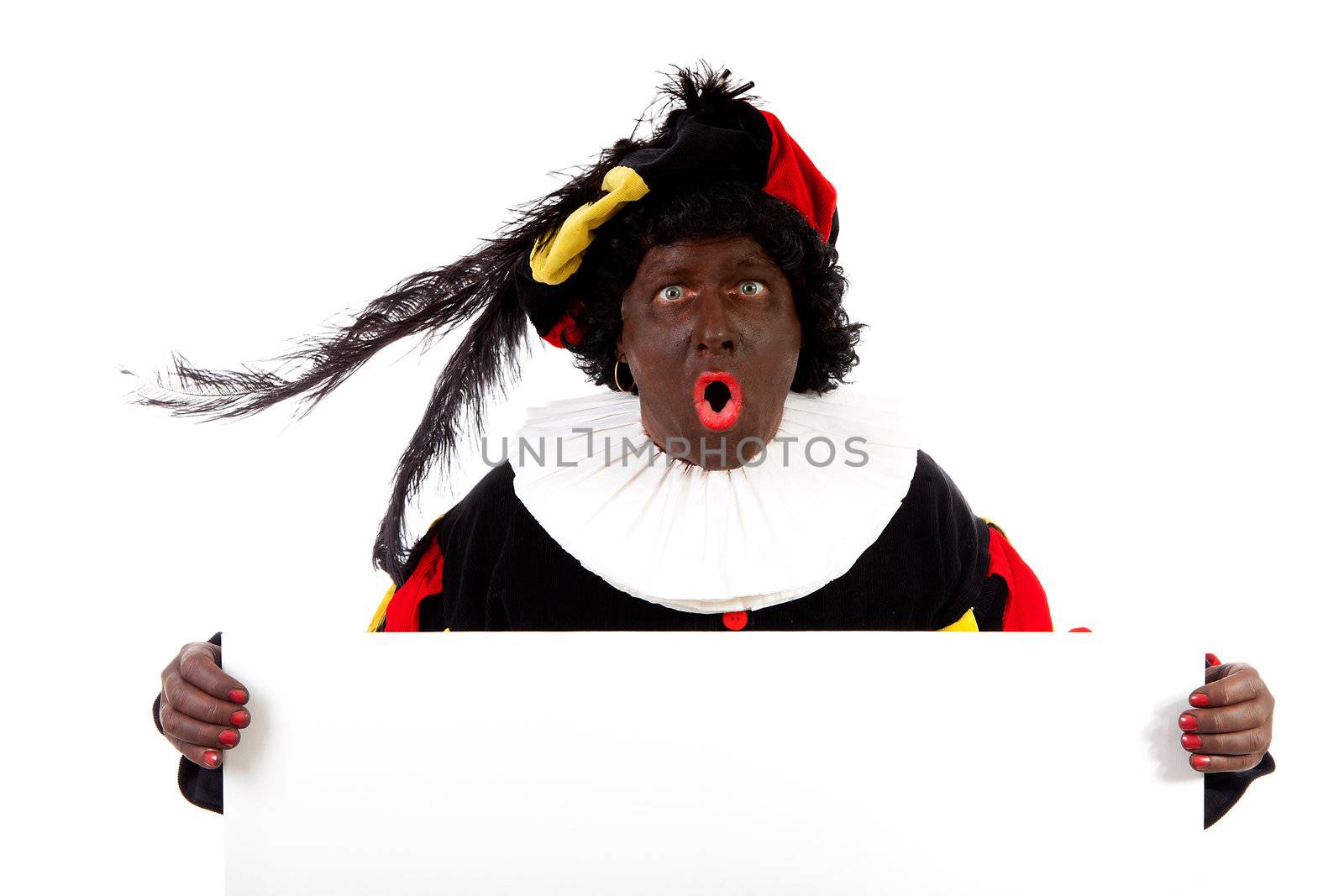 Zwarte piet ( black pete) typical Dutch character part of a traditional event celebrating the birthday of Sinterklaas in december over white background is holding empty text board