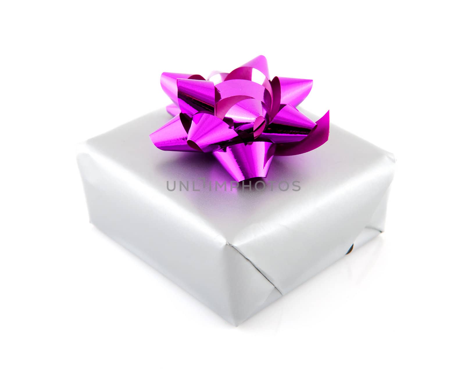 Present wrapped in silver paper and pink ribbon over white background