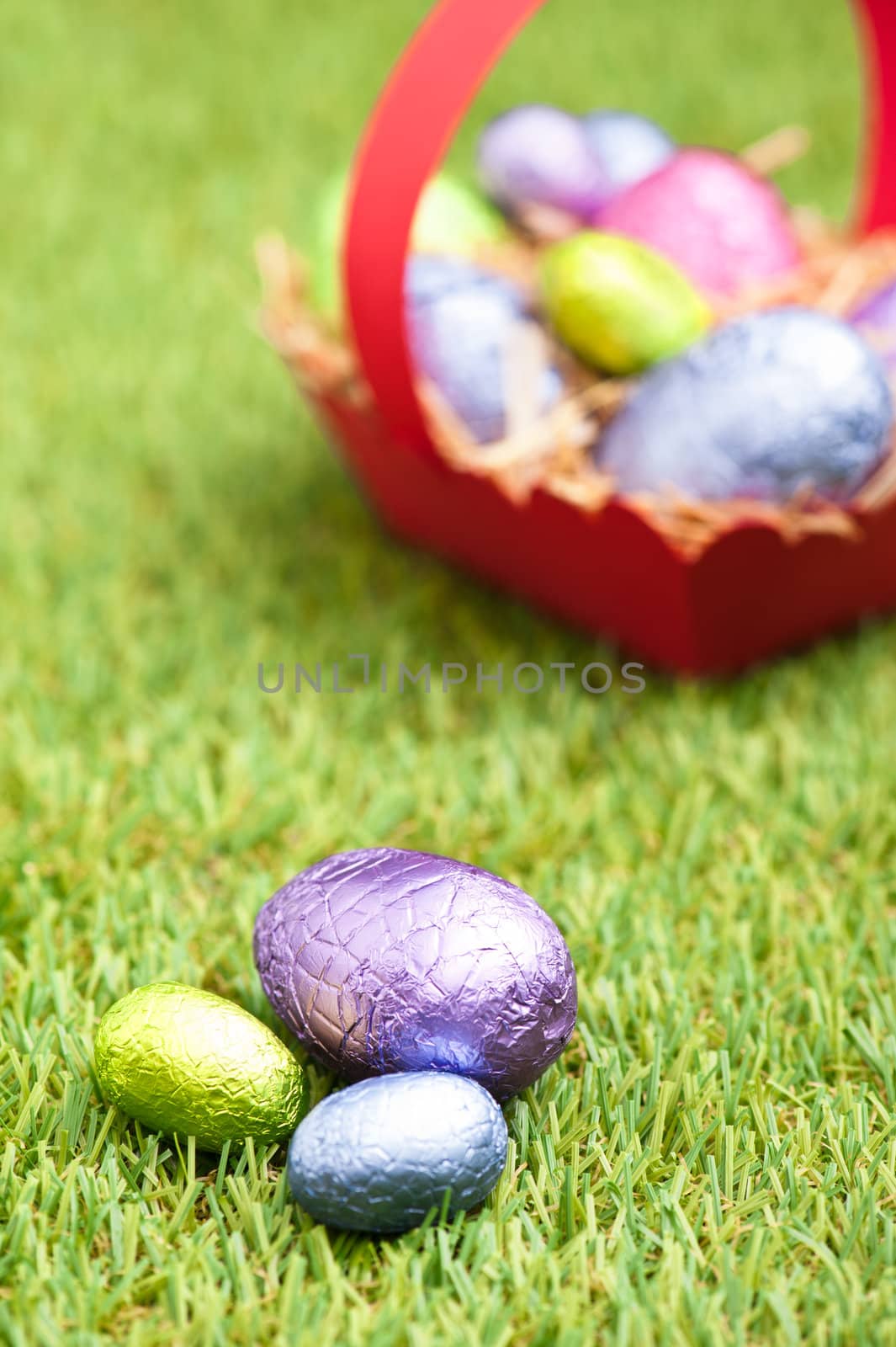 Red basket with Chocolate Easter eggs in an outdoor setting