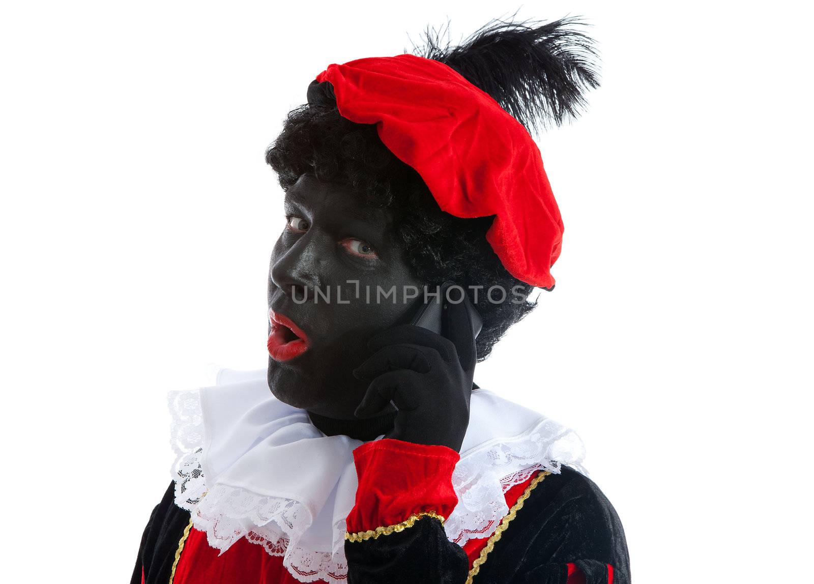 Zwarte piet ( black pete) typical Dutch character part of a traditional event celebrating the birthday of Sinterklaas in december over white background with mobile phone