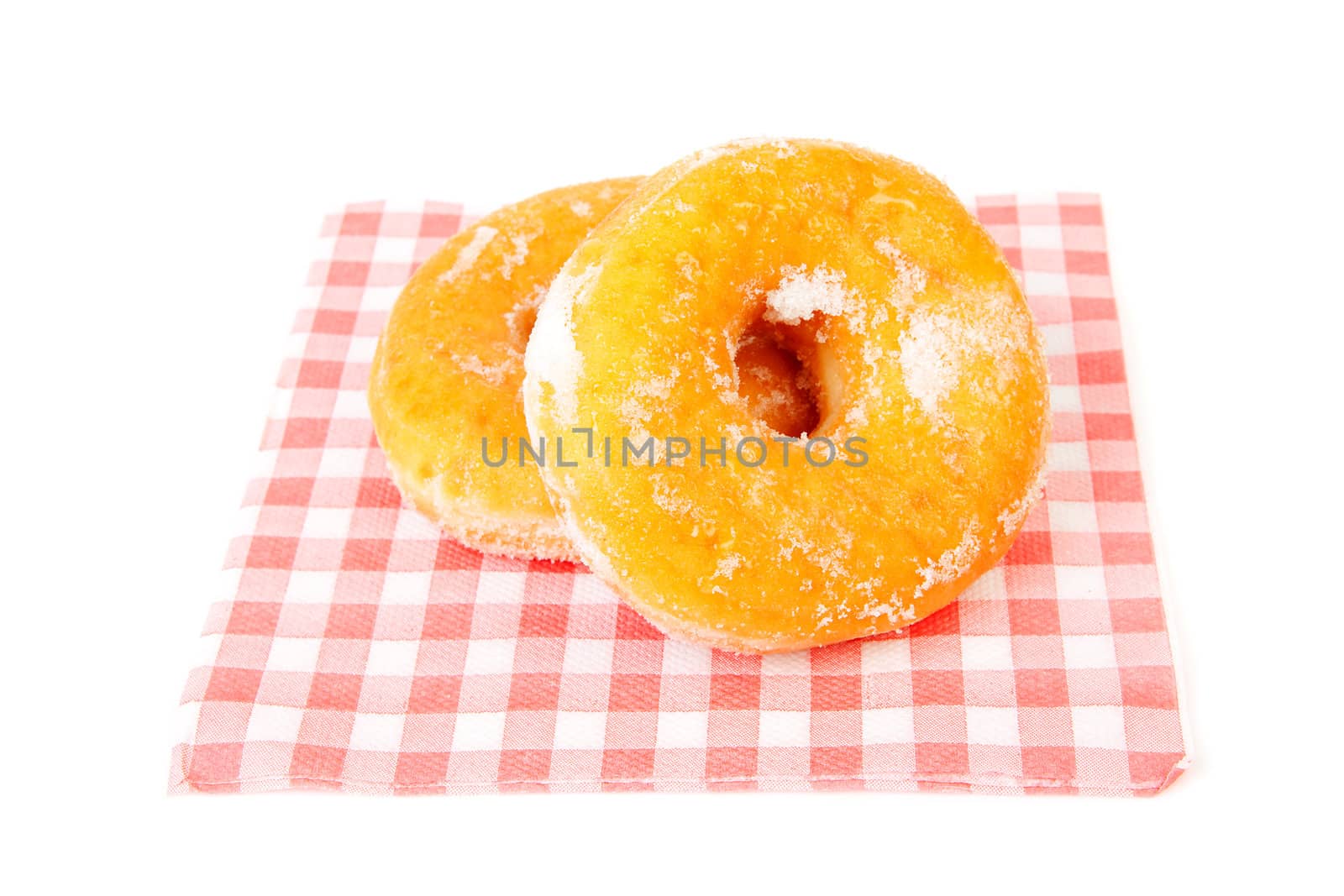 two sugared delicious donuts in napkin over white background