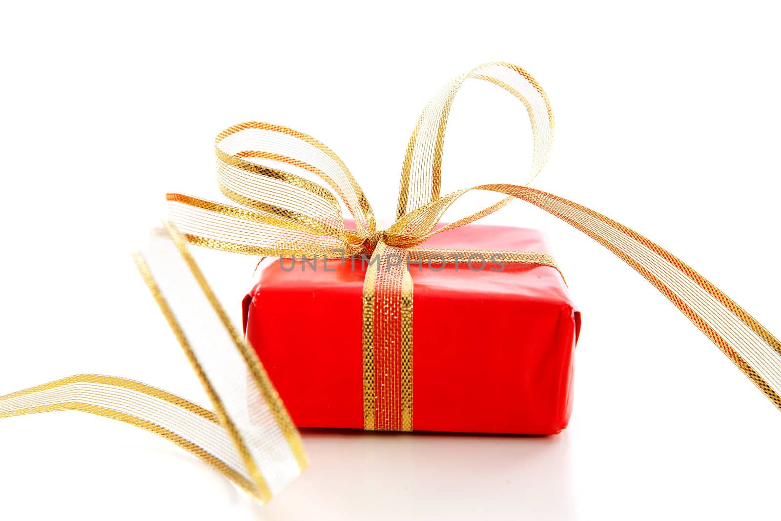 Red present with golden bow over white background