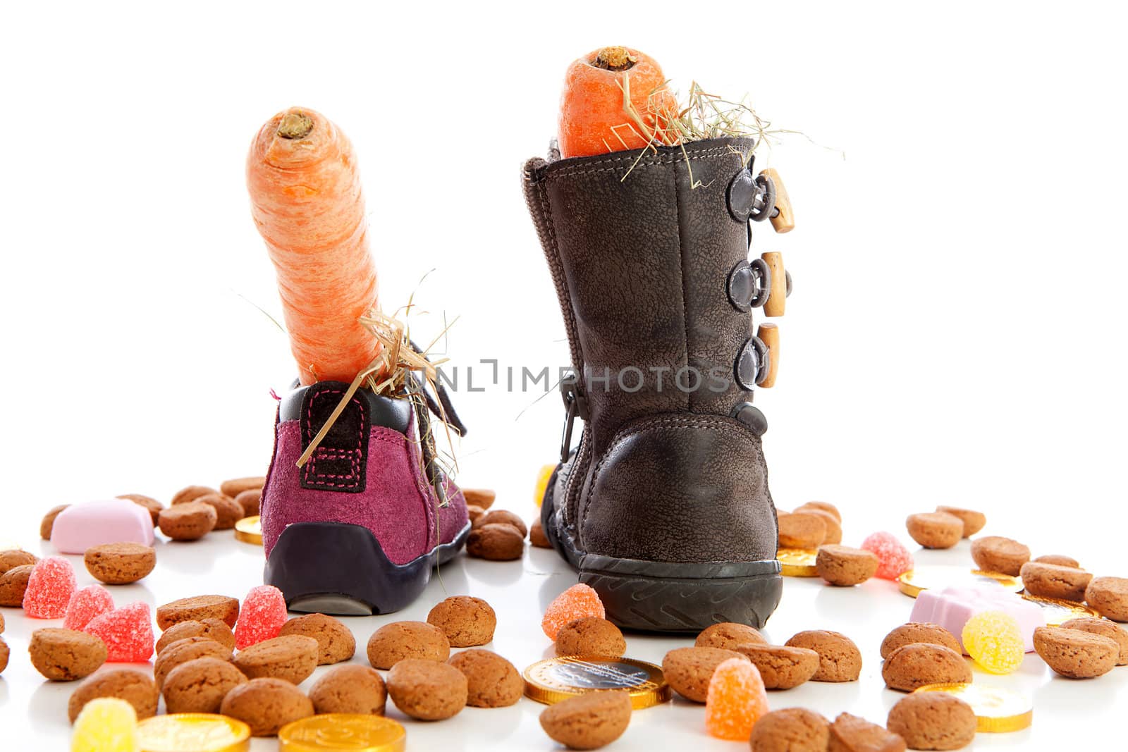 Sinterklaas, typical Dutch event with pepernoten and carrot in shoes over white background