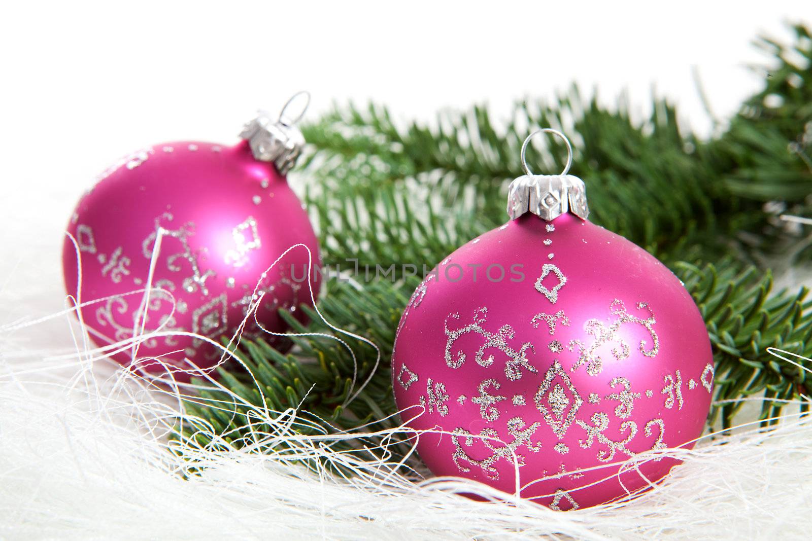 Two pink christmas balls with silver glitters over white background