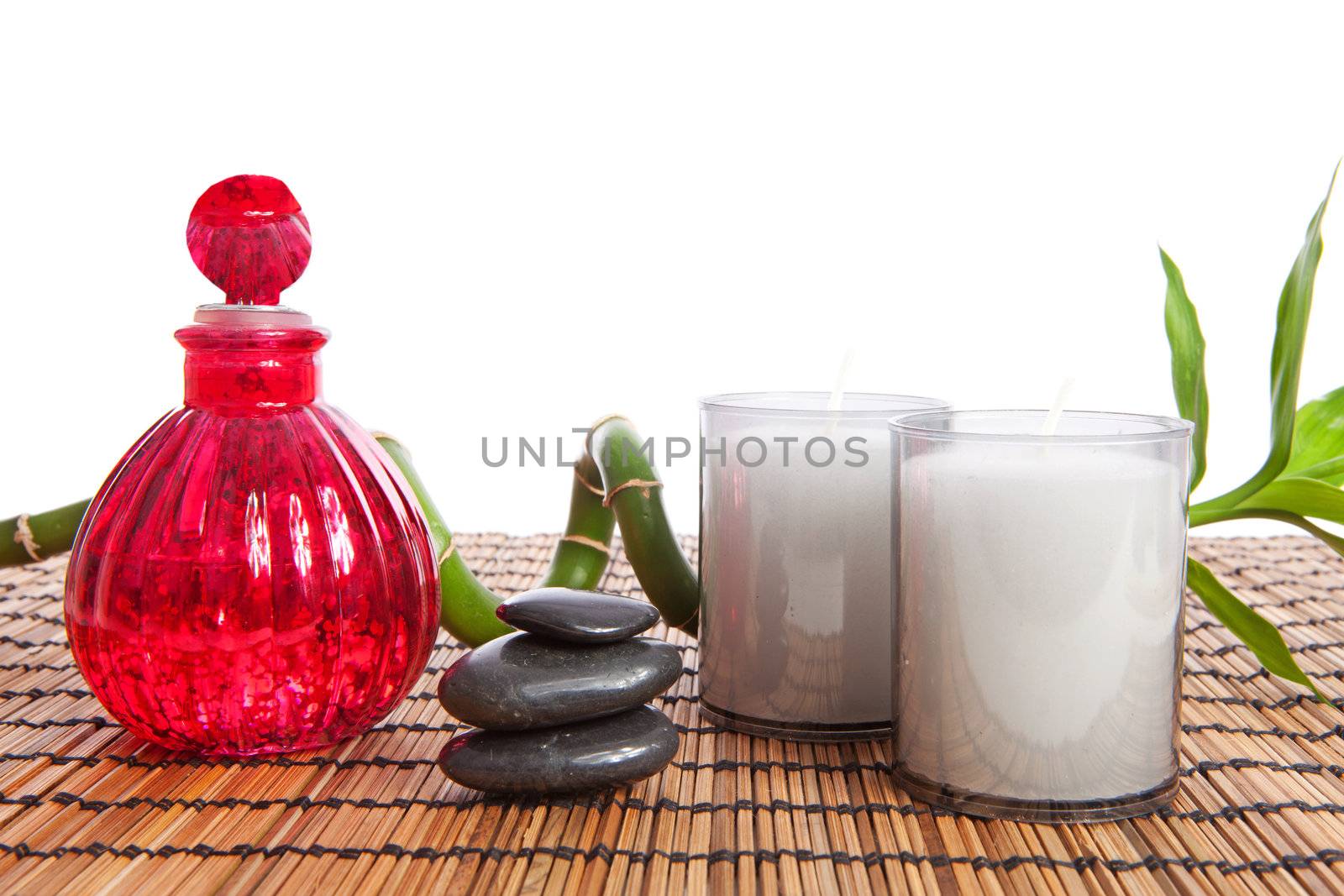 bamboo with black zen stones on cane mat over white background
