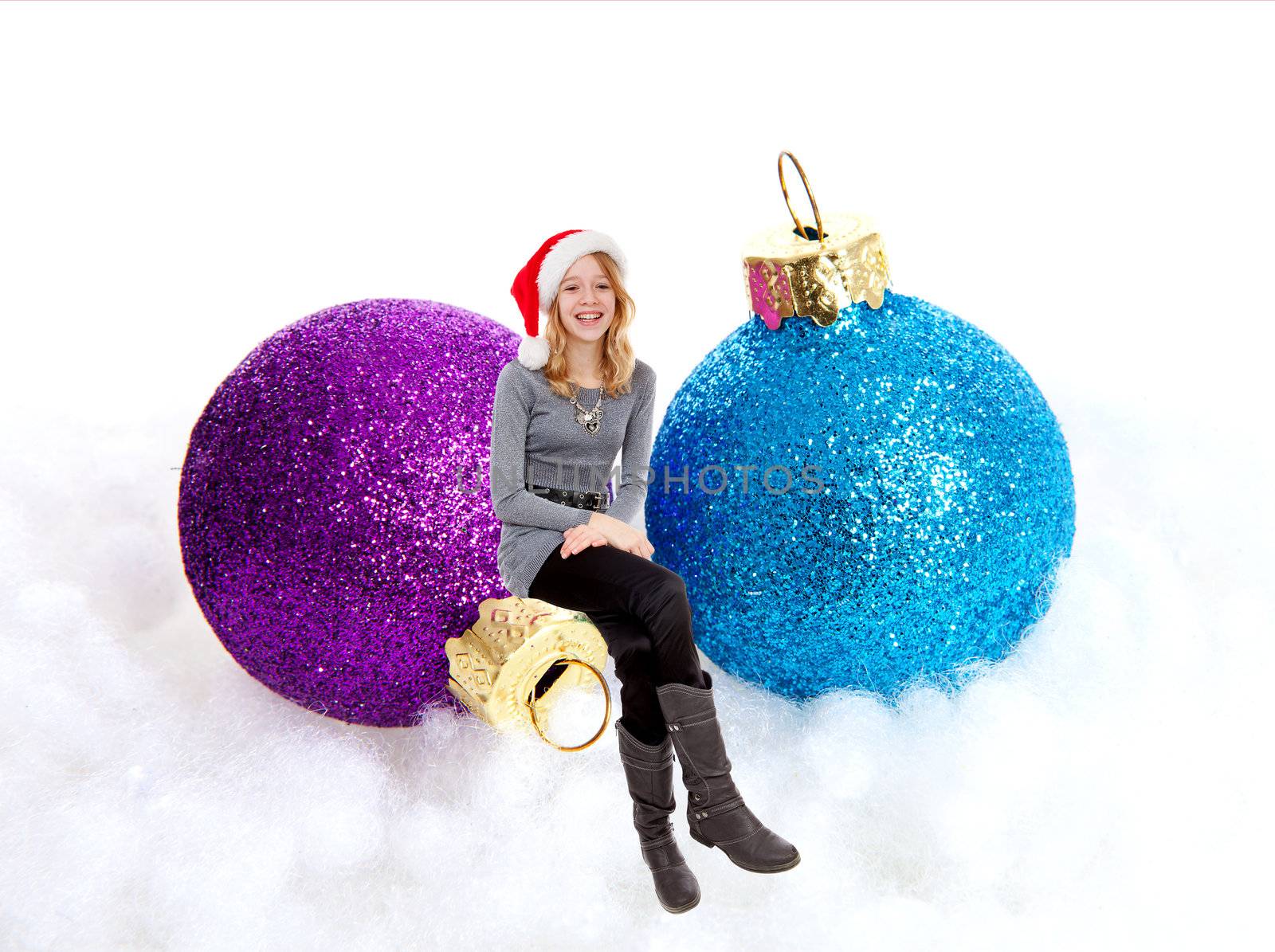 Girl sitting on Christmas balls over white background
