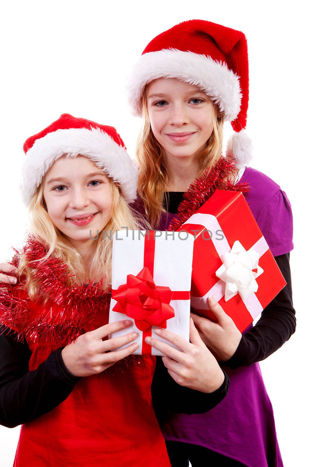Two girl with christmas hat and presents posing over white background