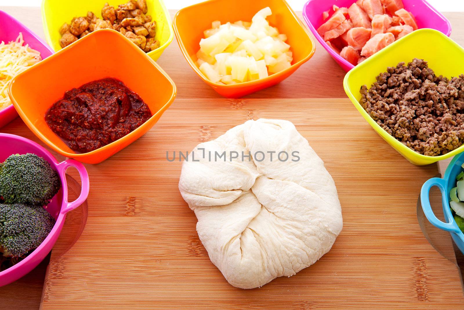 Making pizza: ingredients and pasta dough on wooden cutting board