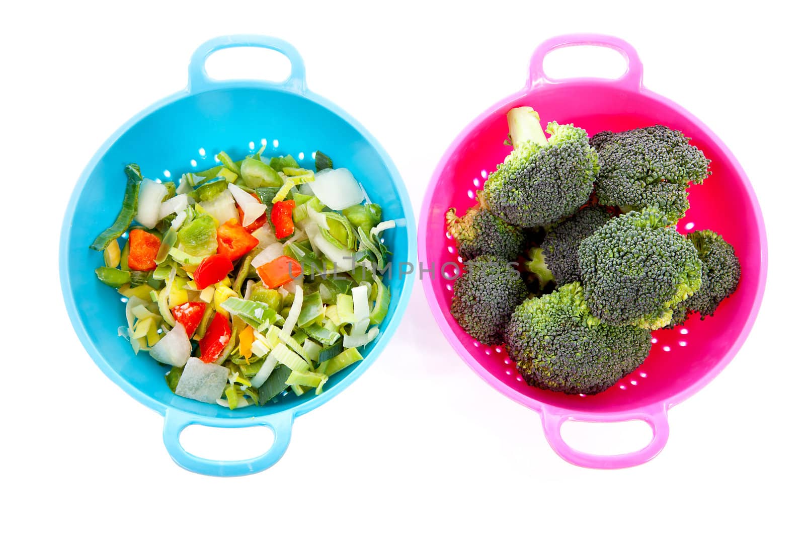 Two colorful colanders with vegetables over white background