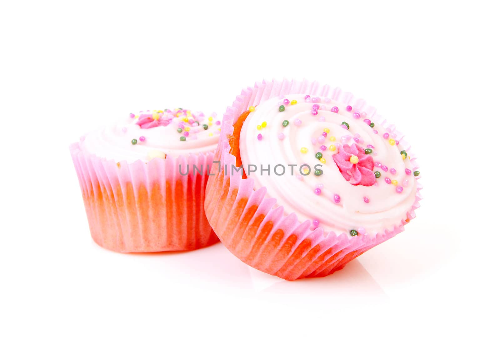 Two delicious pink sweet cupcakes over white background