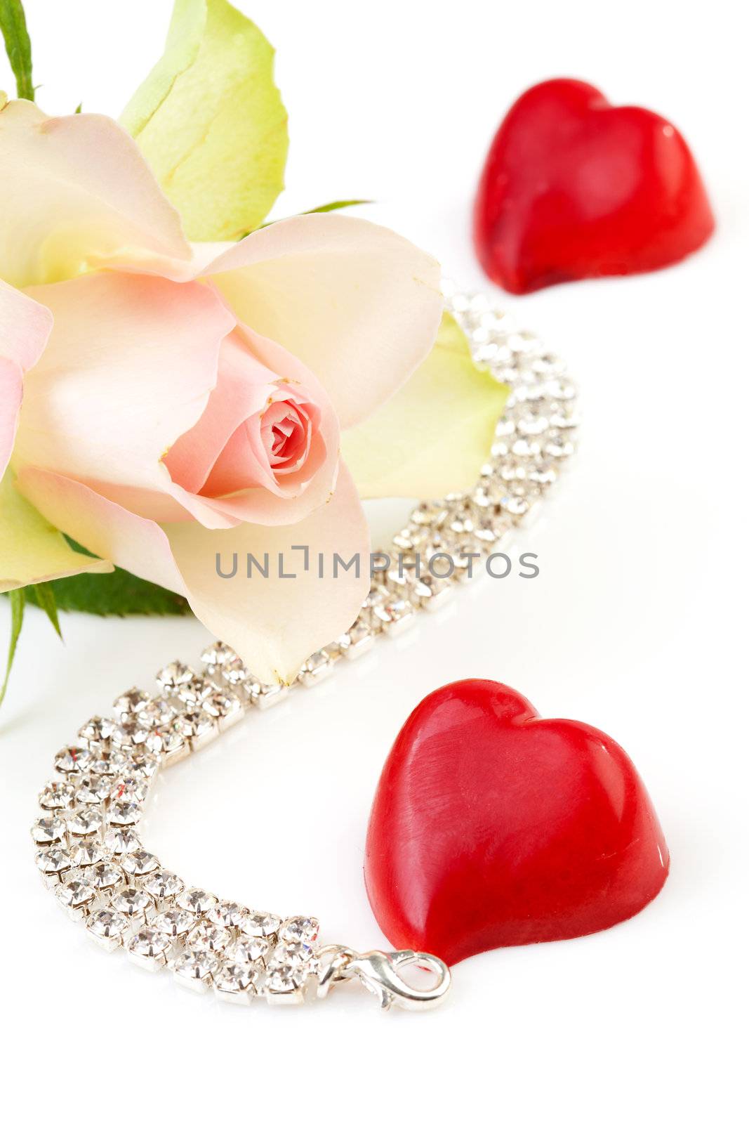 symbolic love and romance with rose, bonbon hart and diamond necklace over white background