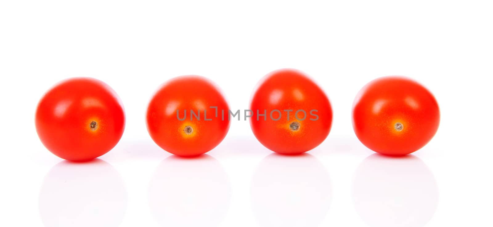 Four cherry tomatoes in a row over white background