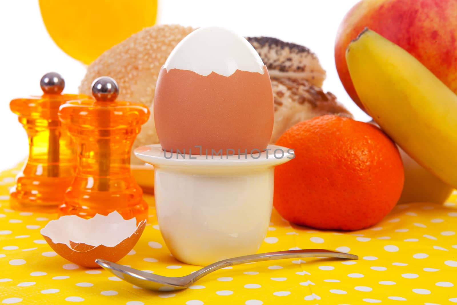Breakfast with peeled egg, delicious bread and fruits in closeup