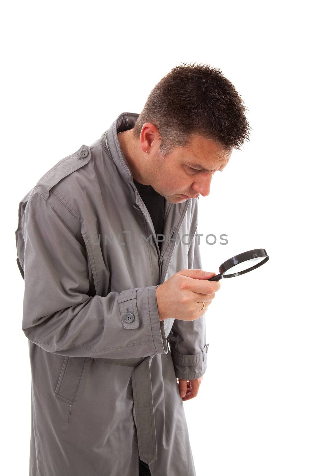 Man with raincoat is looking with magnifying glass over white background