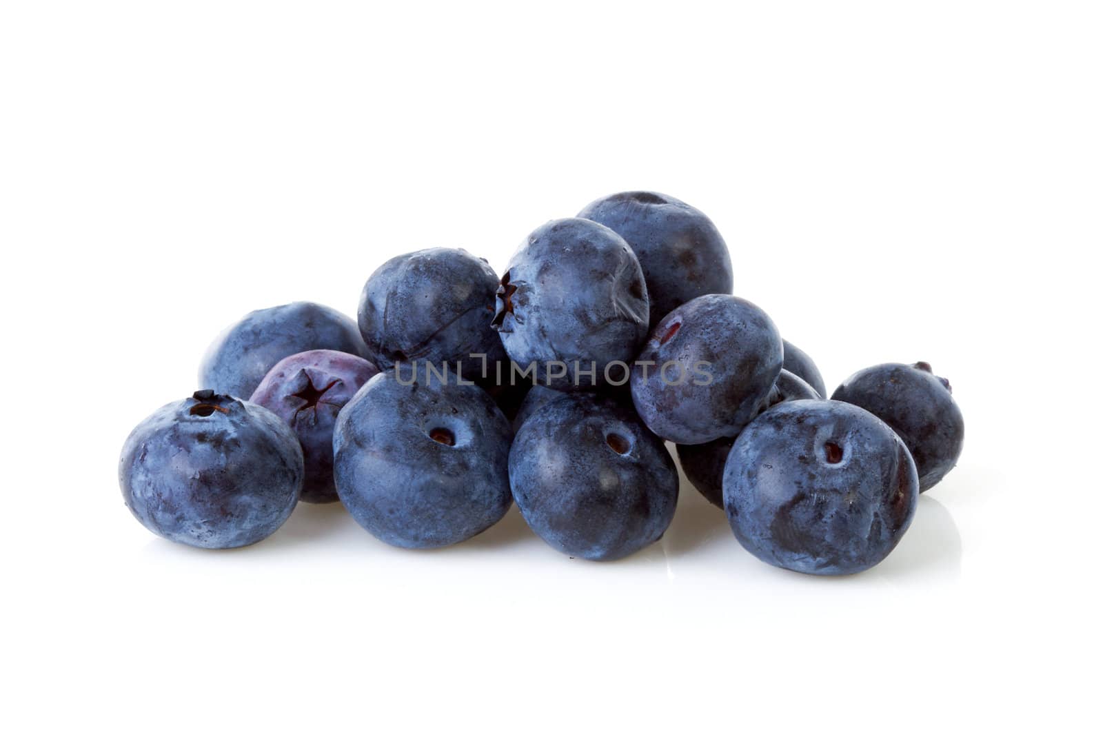 Pile of black currant berries in closeup over white background