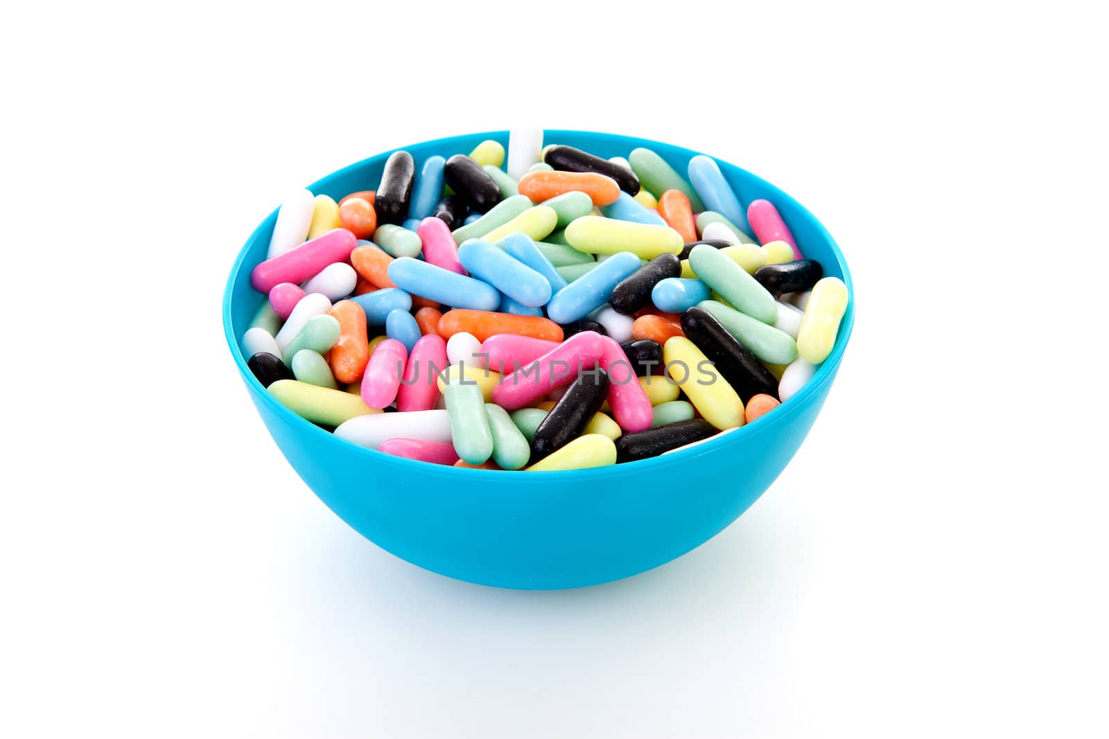 Bowl with colorful laces rods candy over white background
