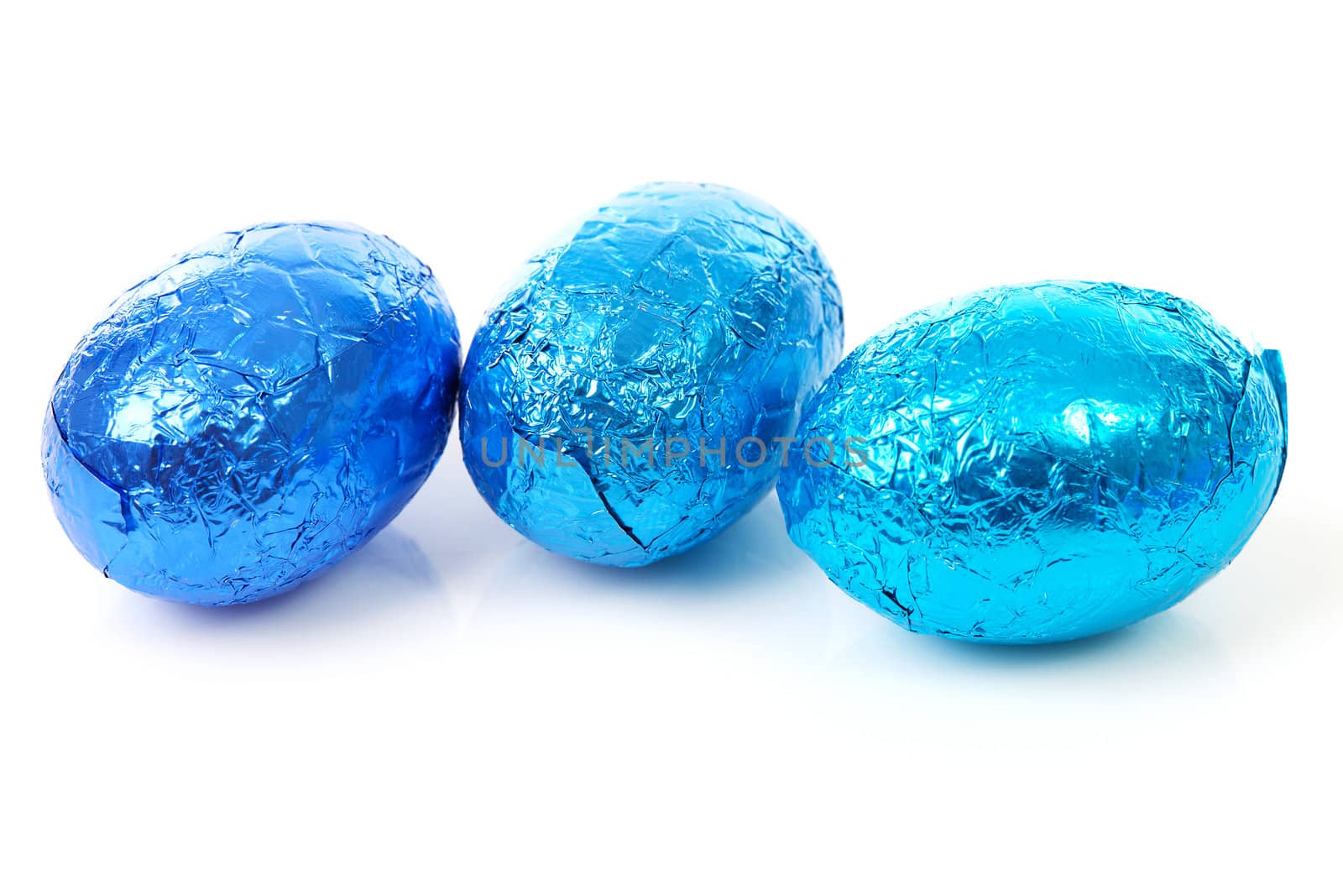 Three blue chocolate easter eggs over white background