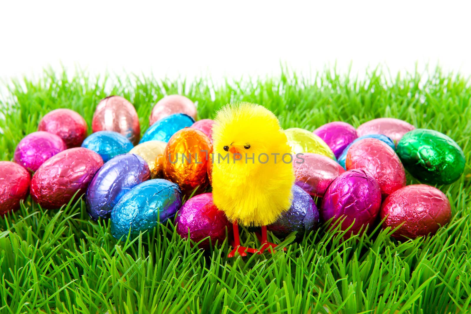 colorful easter eggs and yellow chicken on grass over white background