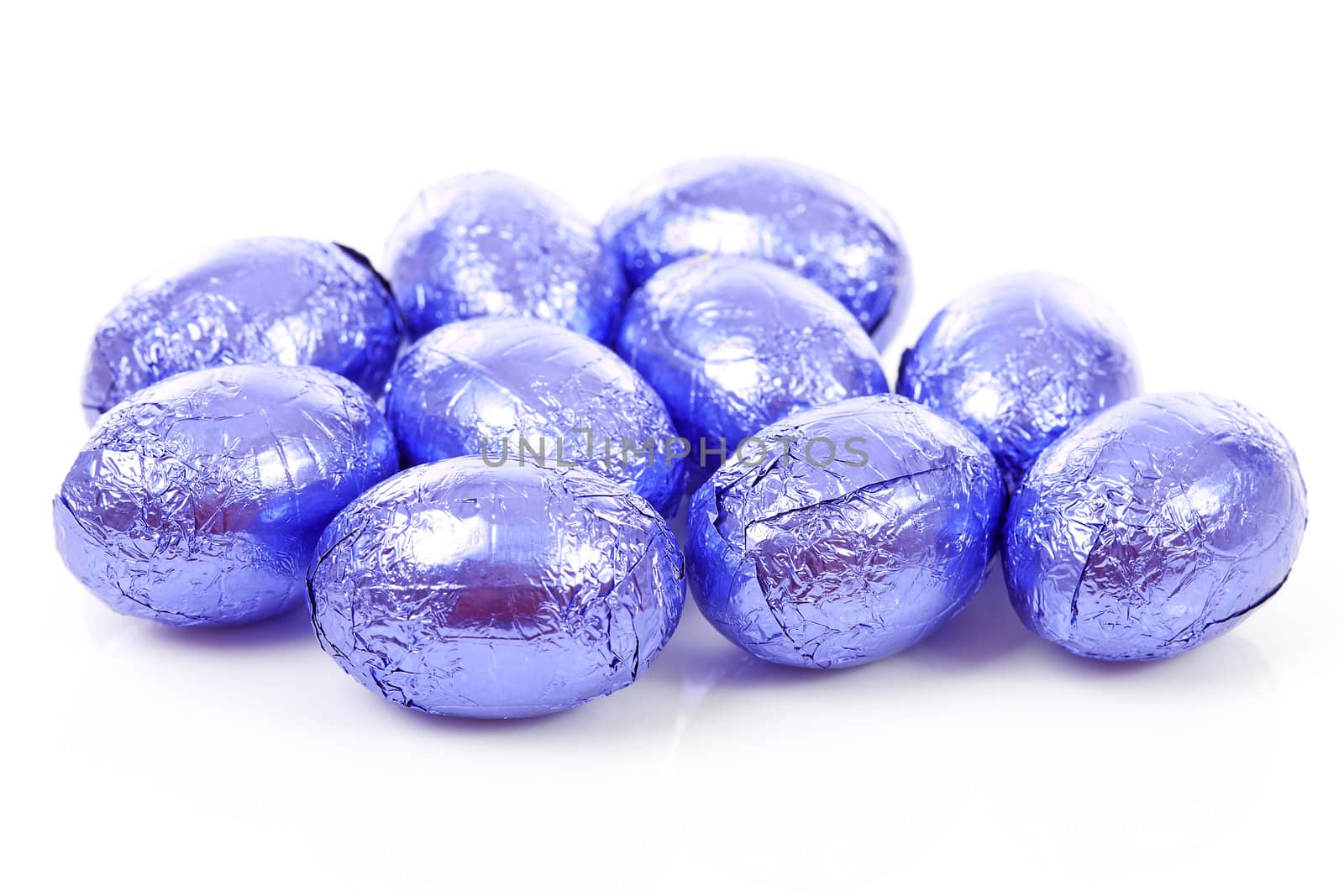 Purple chocolate easter eggs in closeup over white background