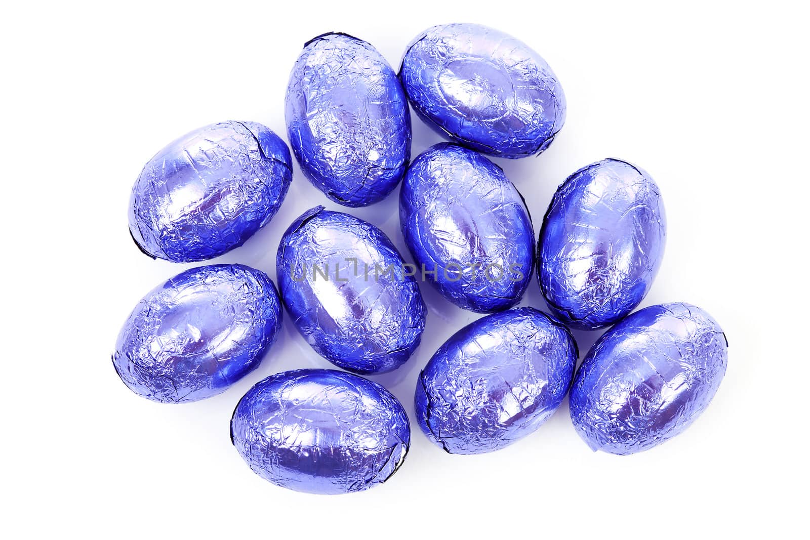 Purple chocolate easter eggs in closeup over white background
