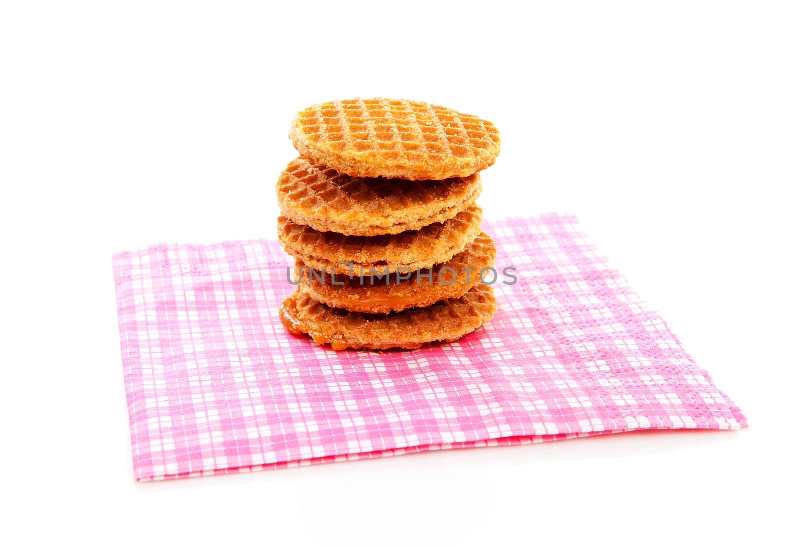 Pile of typical Dutch stroopwafels ( with syrup) on napkin over white background
