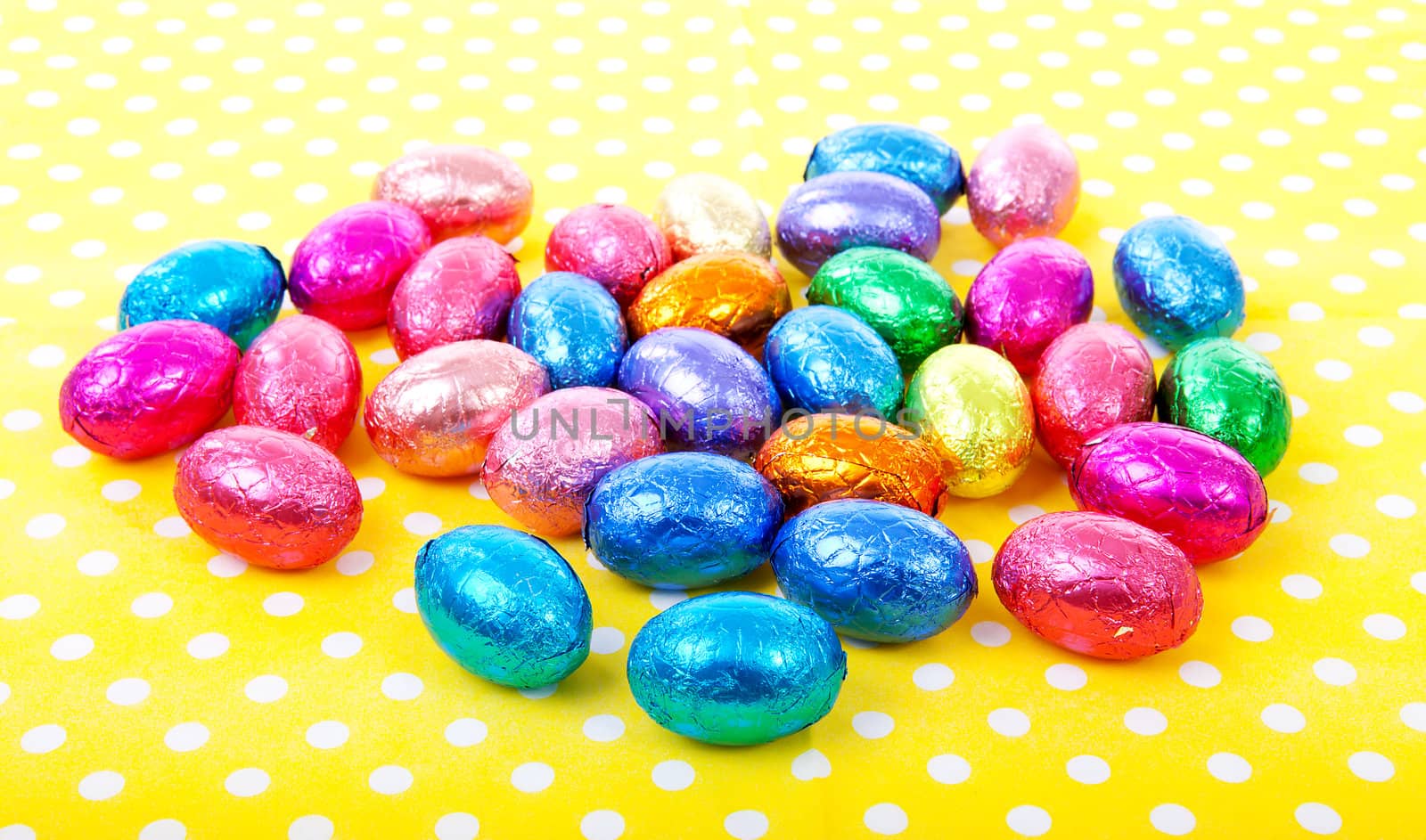 colorful chocolate easter eggs on yellow dotted napkin