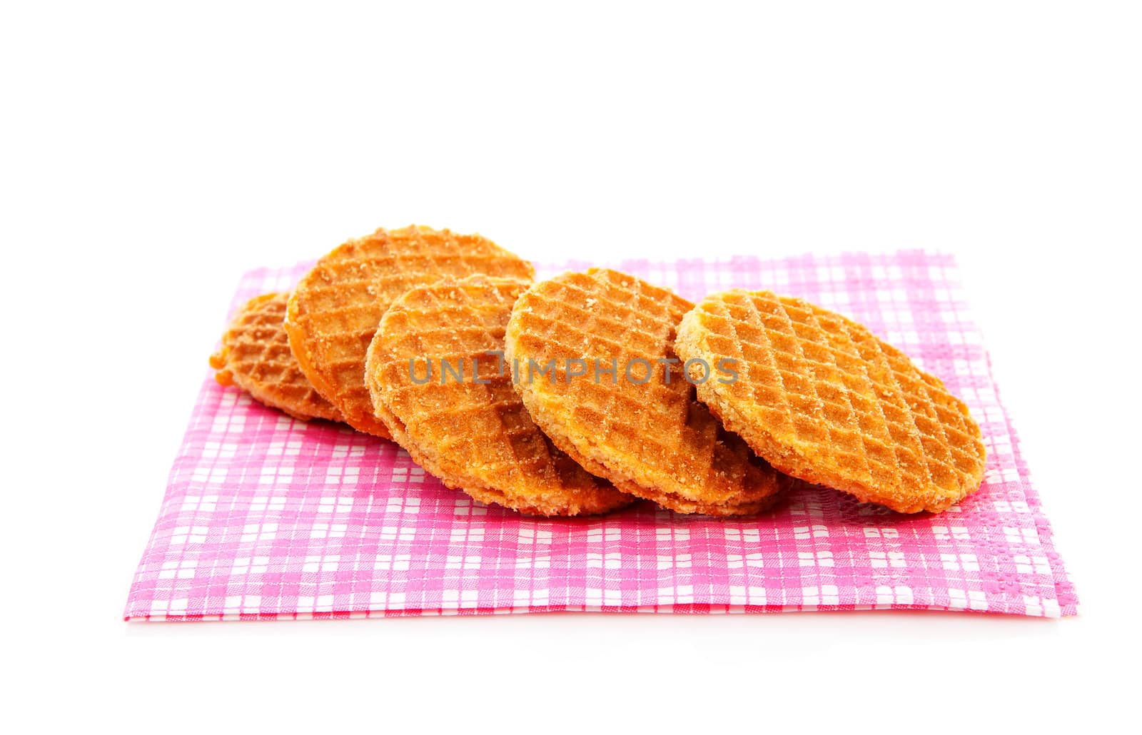 Pile of typical Dutch stroopwafels ( with syrup) on napkin over white background