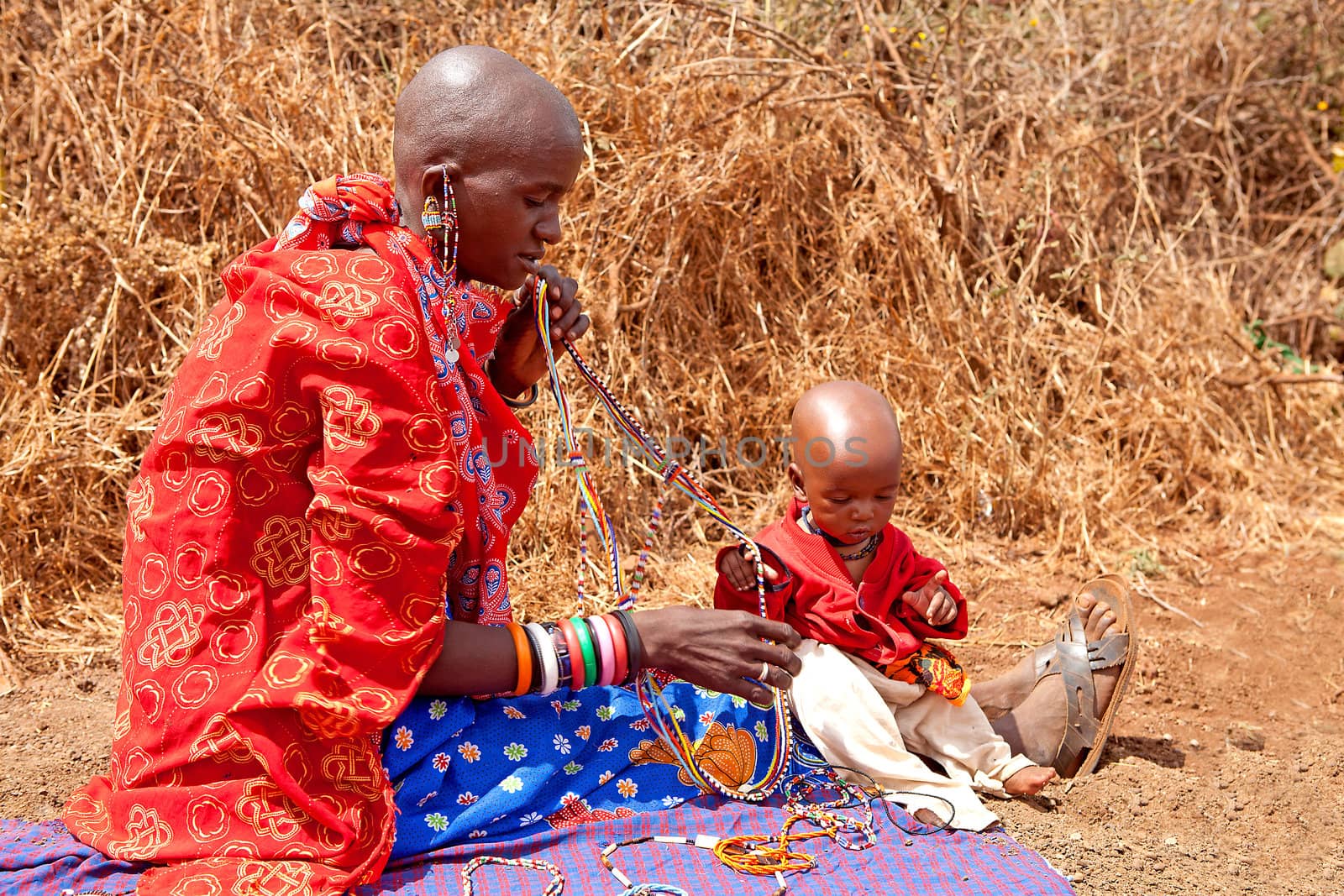 AFRICA, KENYA, MASAI MARA - JULY 2: Masai woman with child is showing and selling traditional jewelry as cultural ceremony near to Masai Mara National Park Reserve, July 2,2011,Kenya
