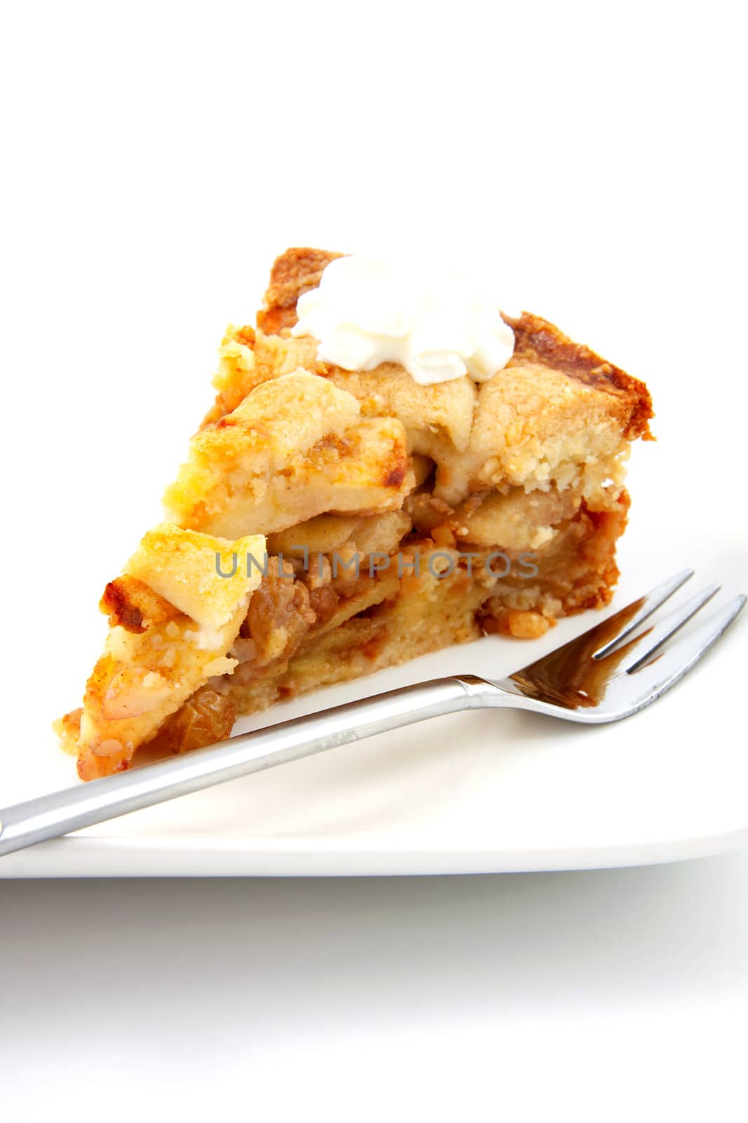 Piece of apple pie with whipped cream on white background