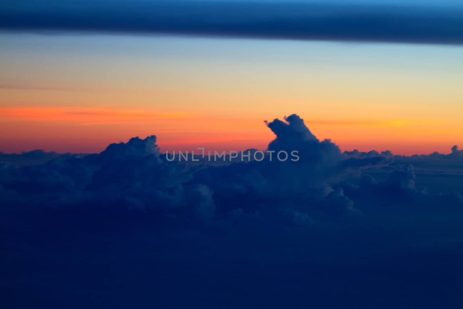 Sunset view above the clouds seen from airplane window

