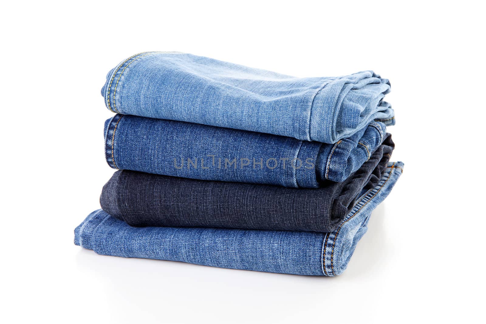 Pile of blue jeans over white background
