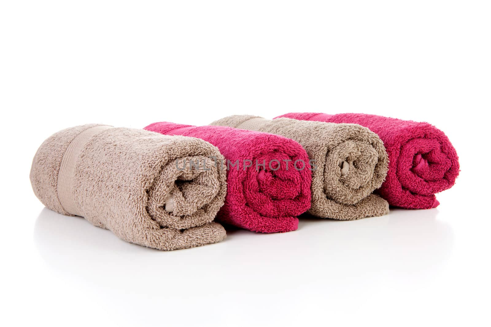 Four rolled colorful towels over white background