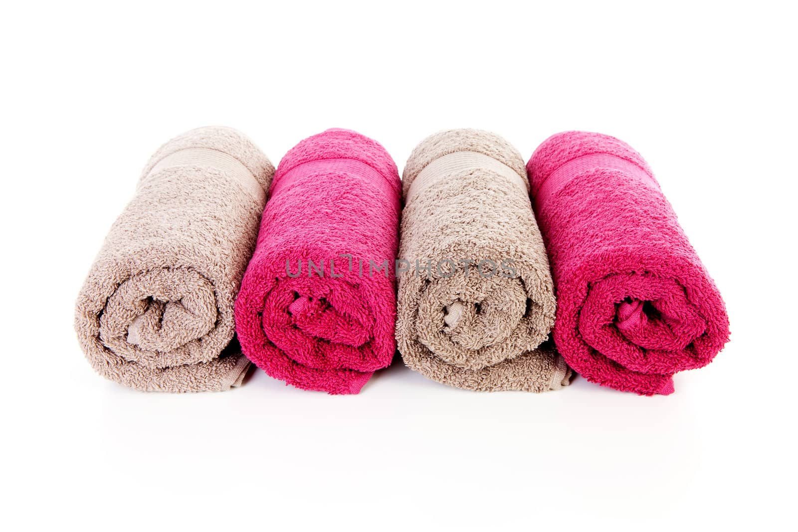 Four rolled colorful towels over white background