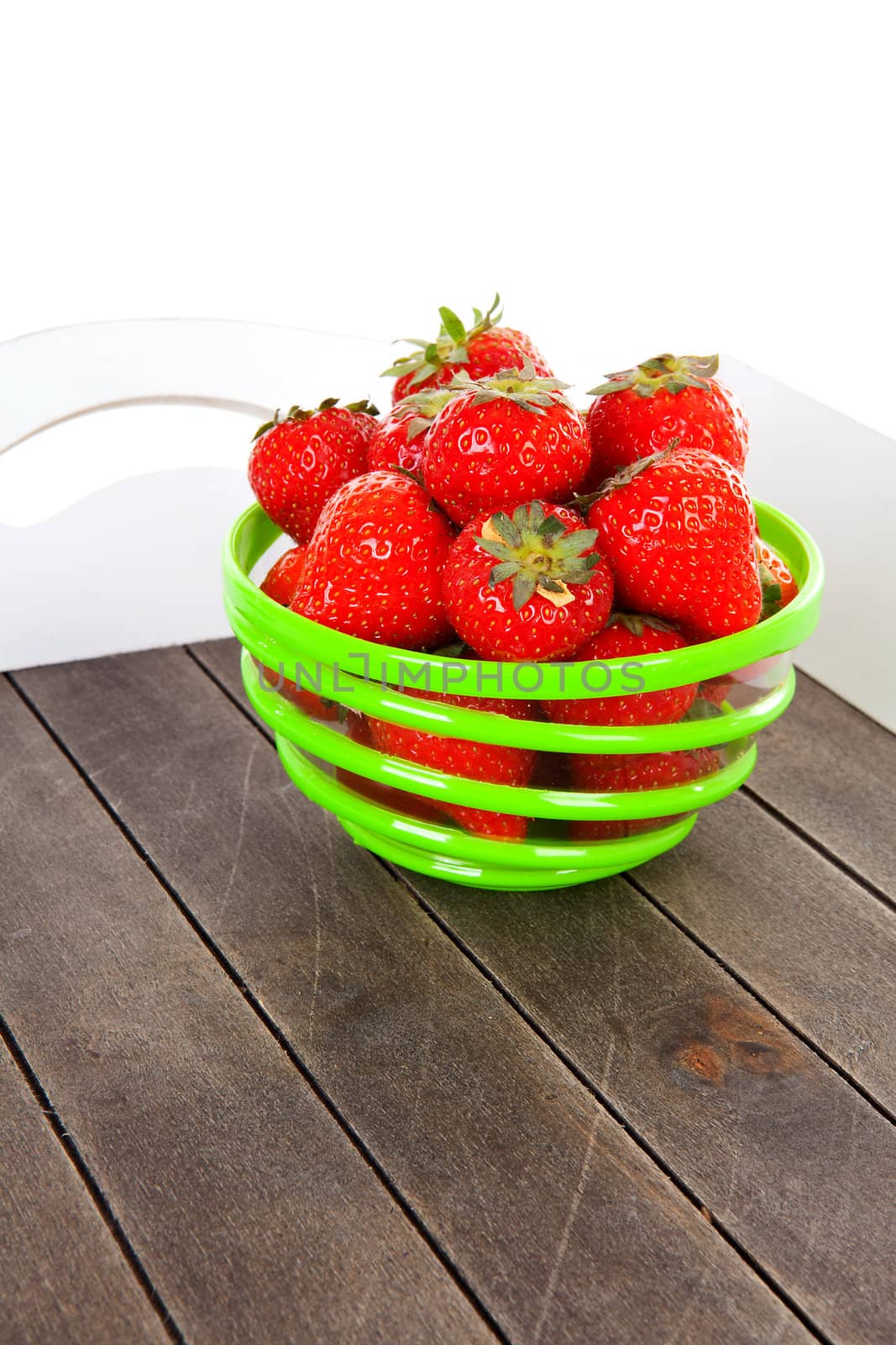 Tray with bowl of fresh strawberries over white background
