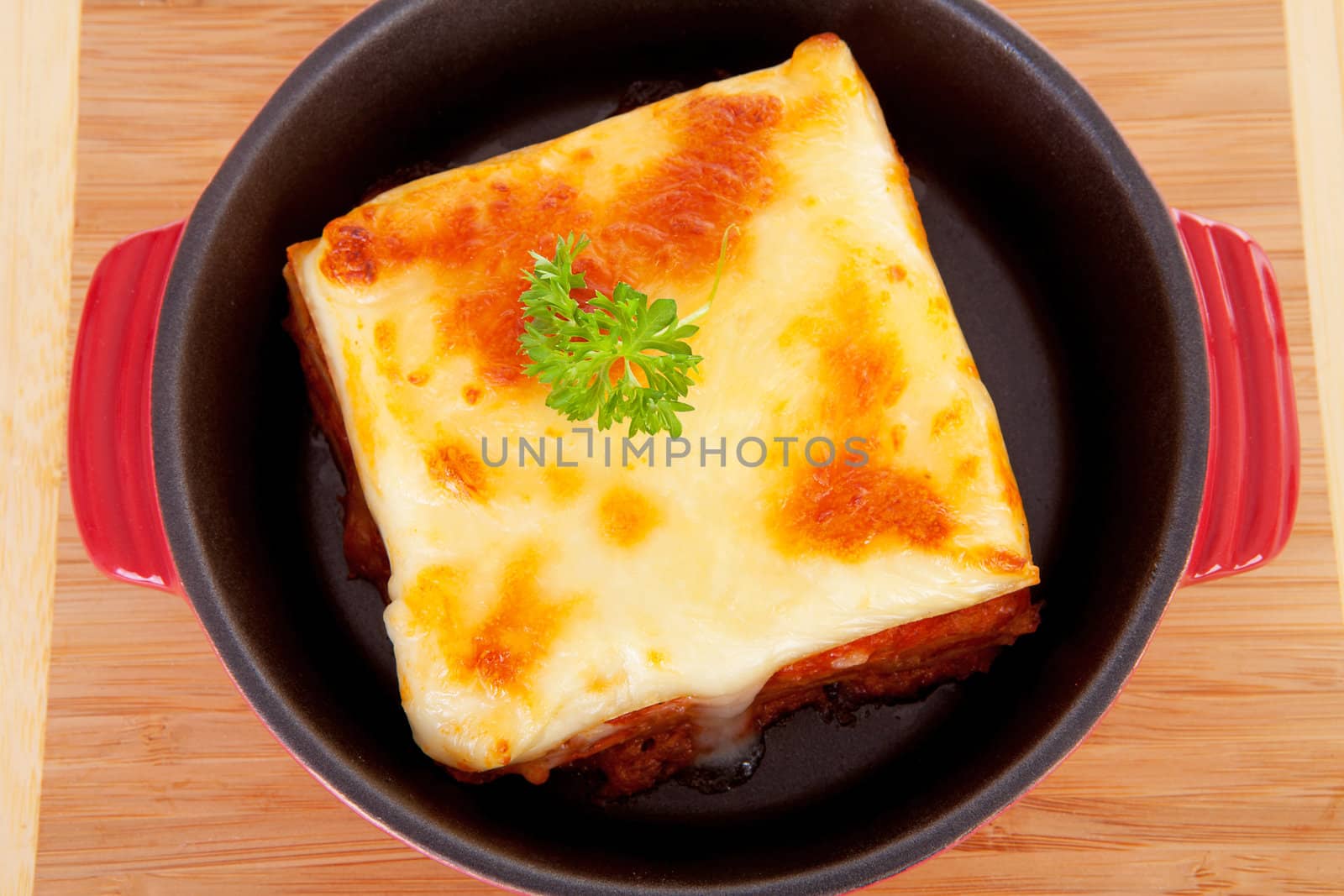 Lasagna dinner in pan on wooden cutting board
